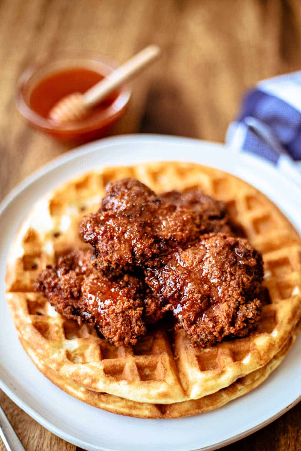 chicken and waffles with honey sriracha sauce in the background
