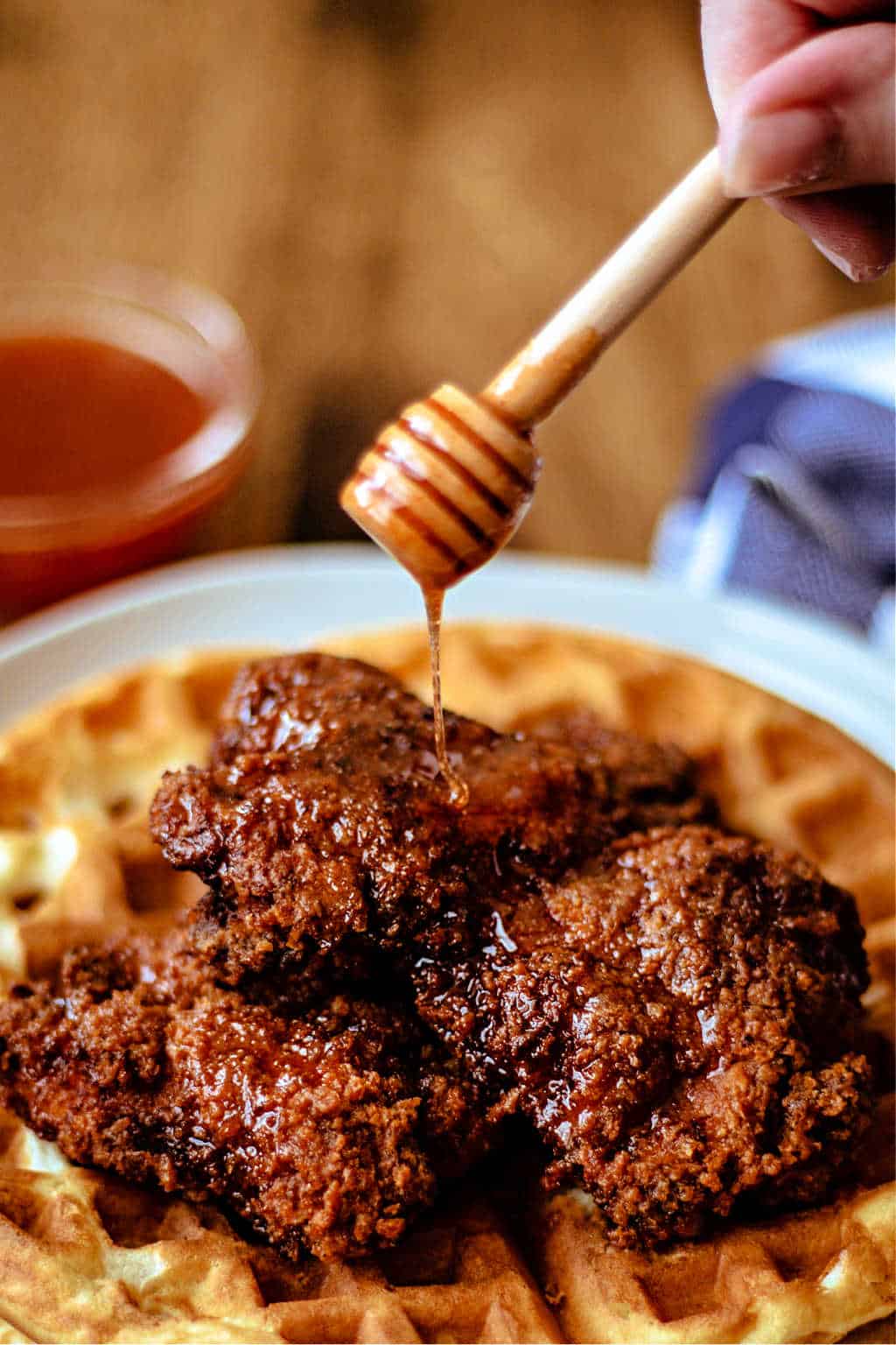 drizzling honey sriracha sauce on chicken and waffles