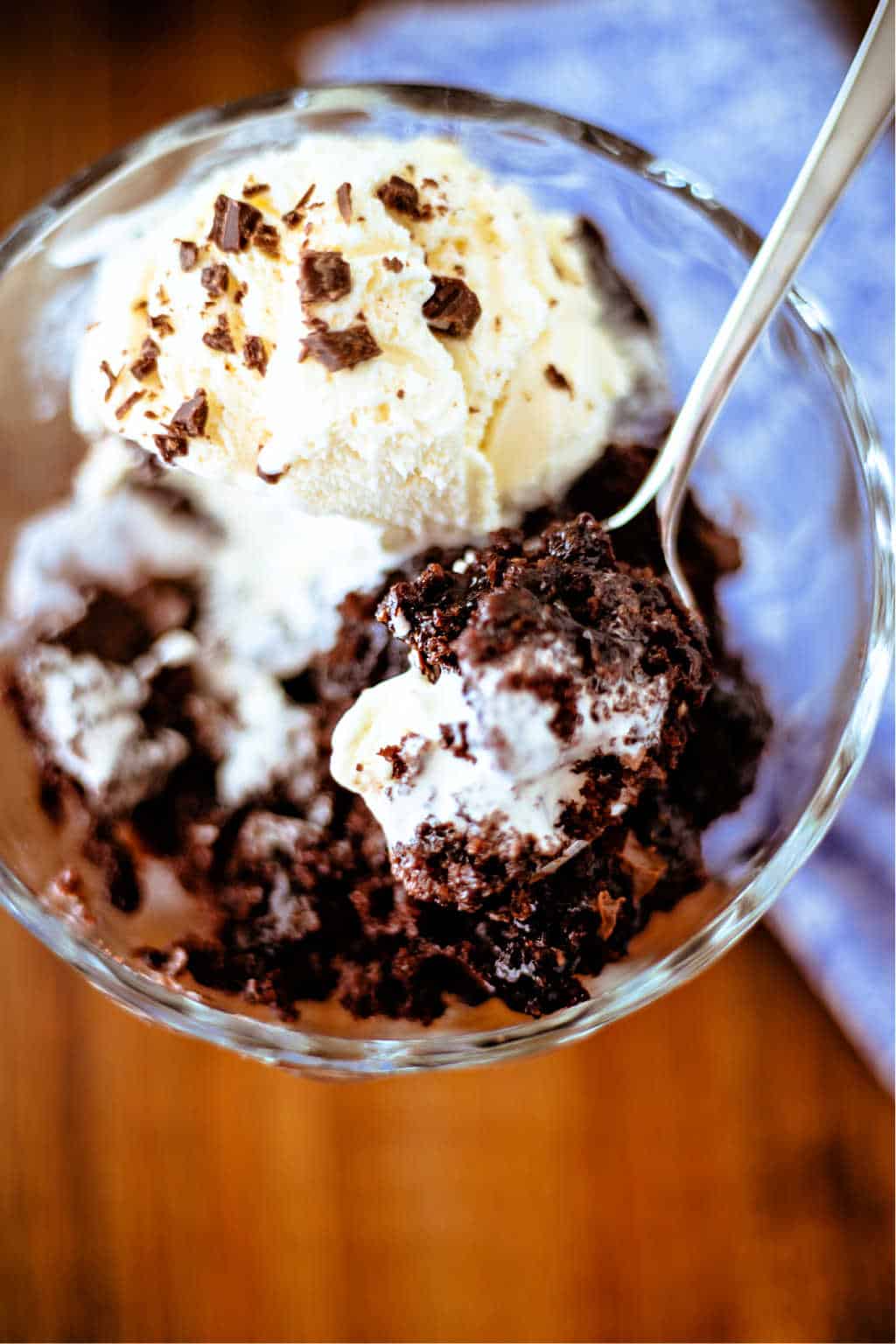 chocolate pudding cake in a glass dish with a scoop of vanilla ice cream