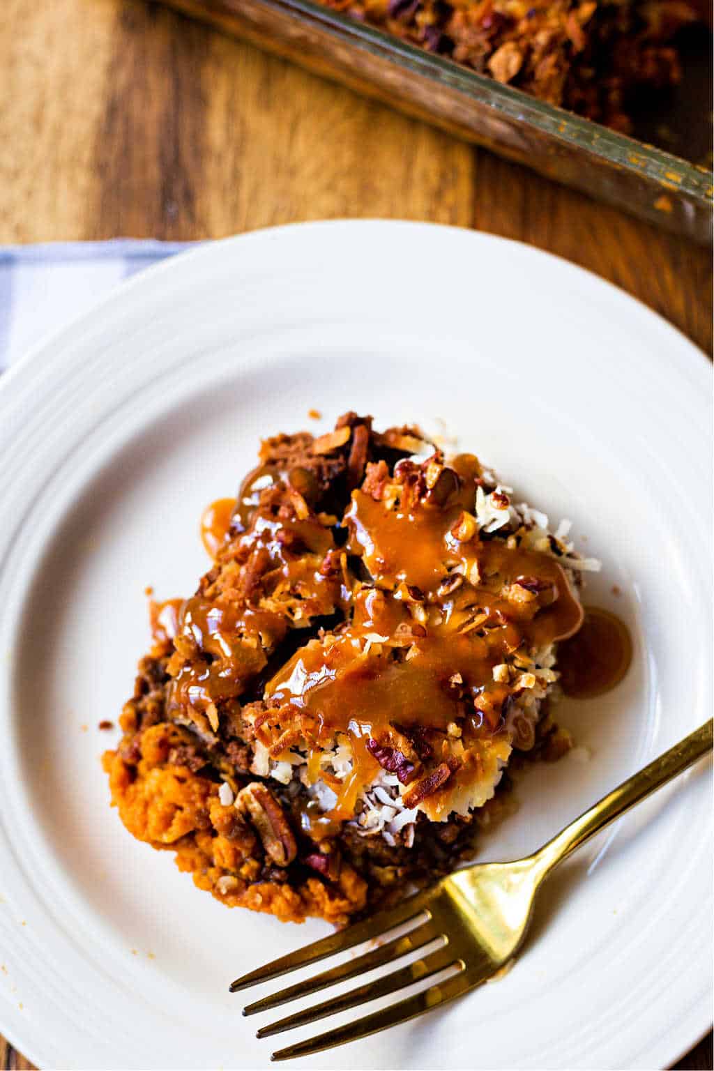 german chocolate pumpkin dump cake on a white plate with a gold fork