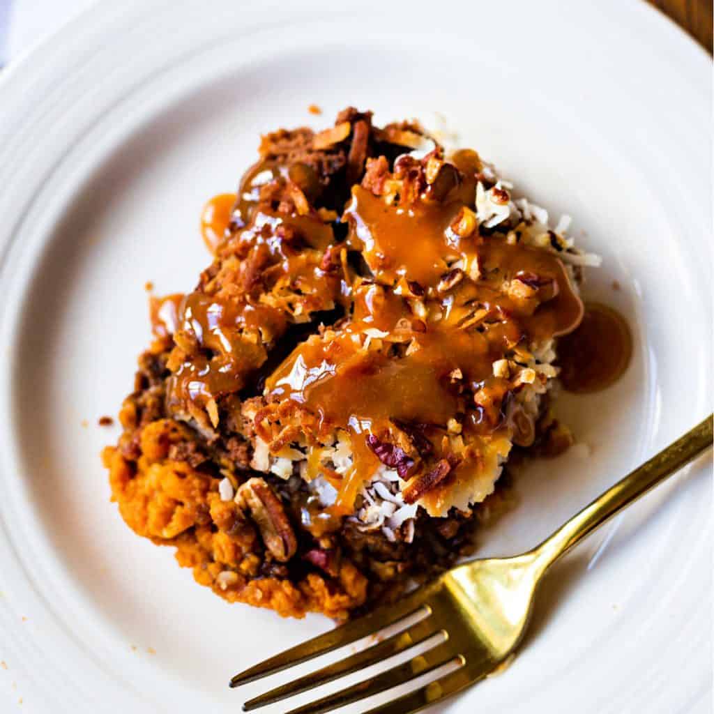 german chocolate pumpkin dump cake on a white plate with a gold fork