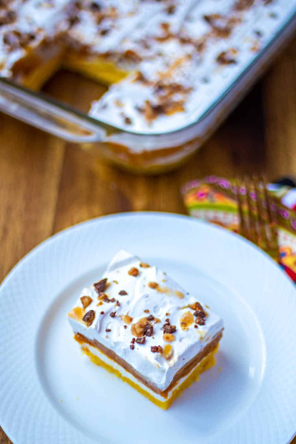 a slice of pumpkin delight on a plate on a wooden table