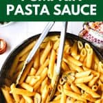 penne pasta with pumpkin pasta sauce in a skillet with tongs