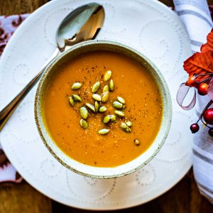 a bowl of butternut squash soup on a white plate