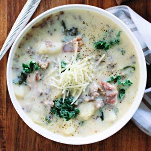 a bowl of zuppa toscana soup on a wooden table