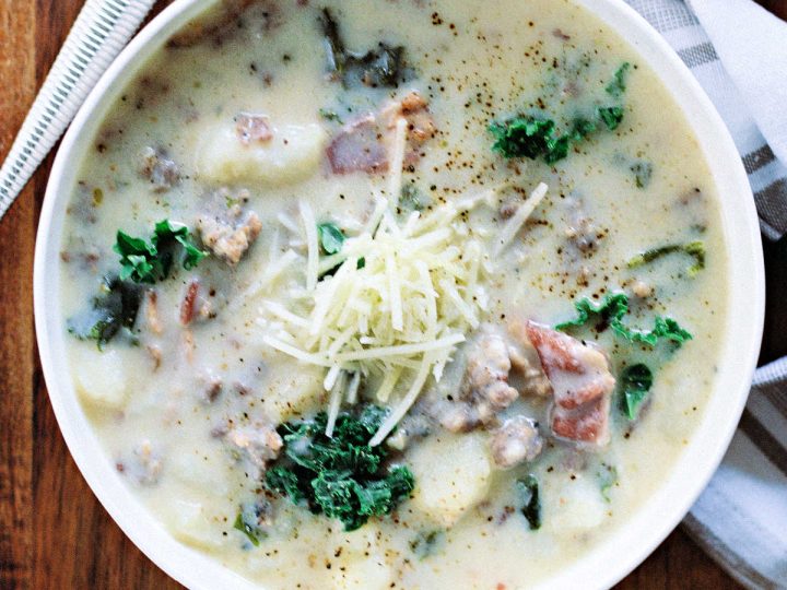 a bowl of zuppa toscana soup on a wooden table