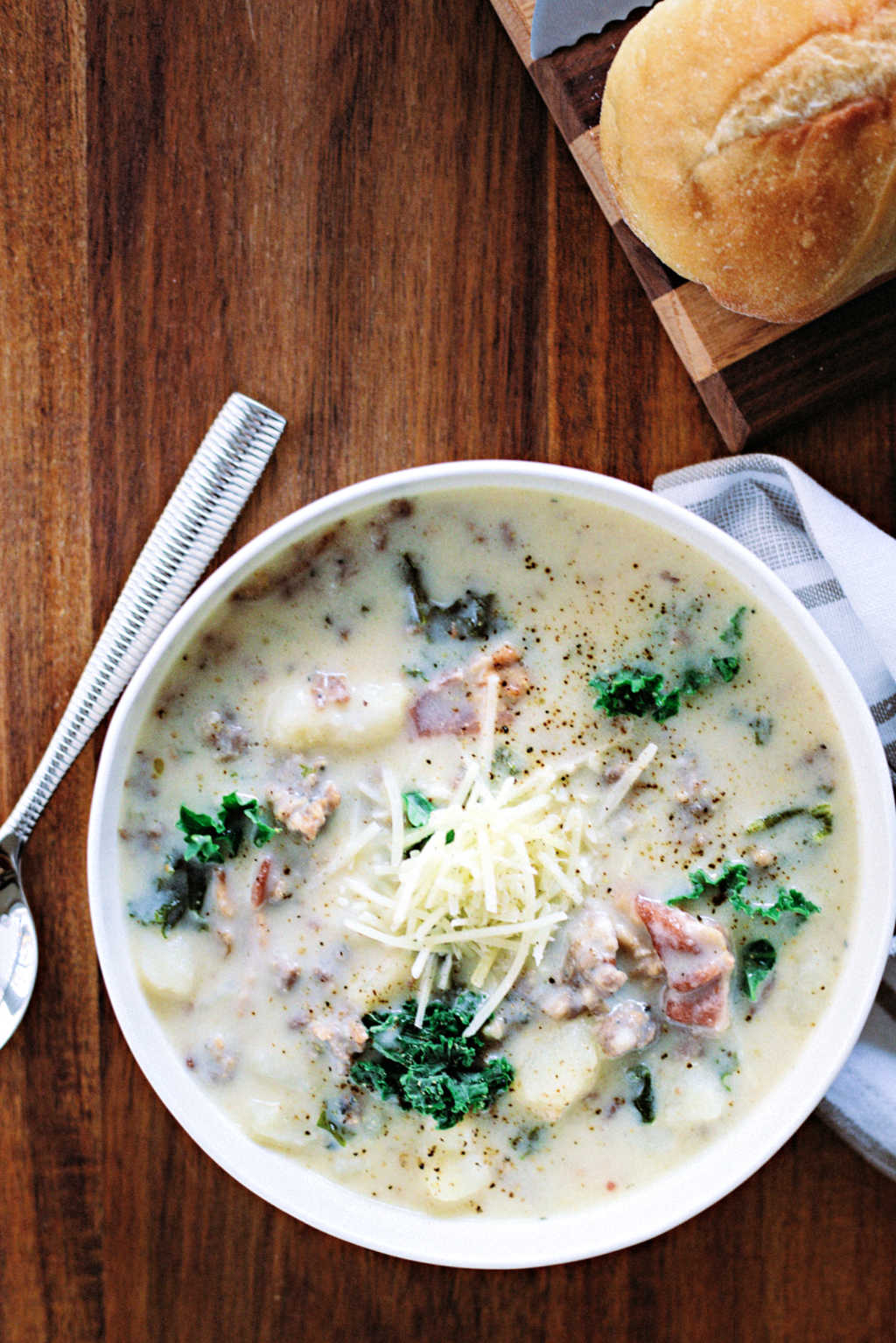 a bowl of zuppa toscana soup on a wooden table