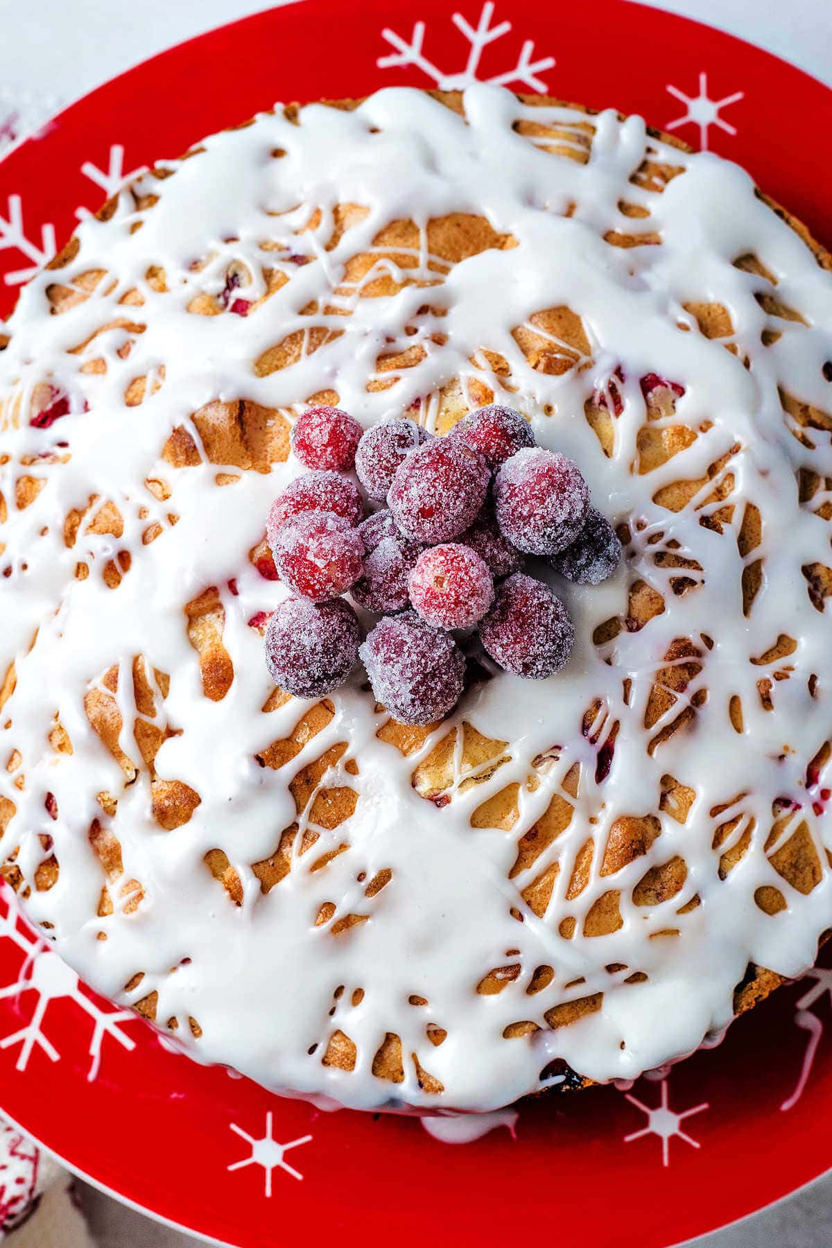 Sugard cranberries piled into the center of a craberry cake as a garnish.