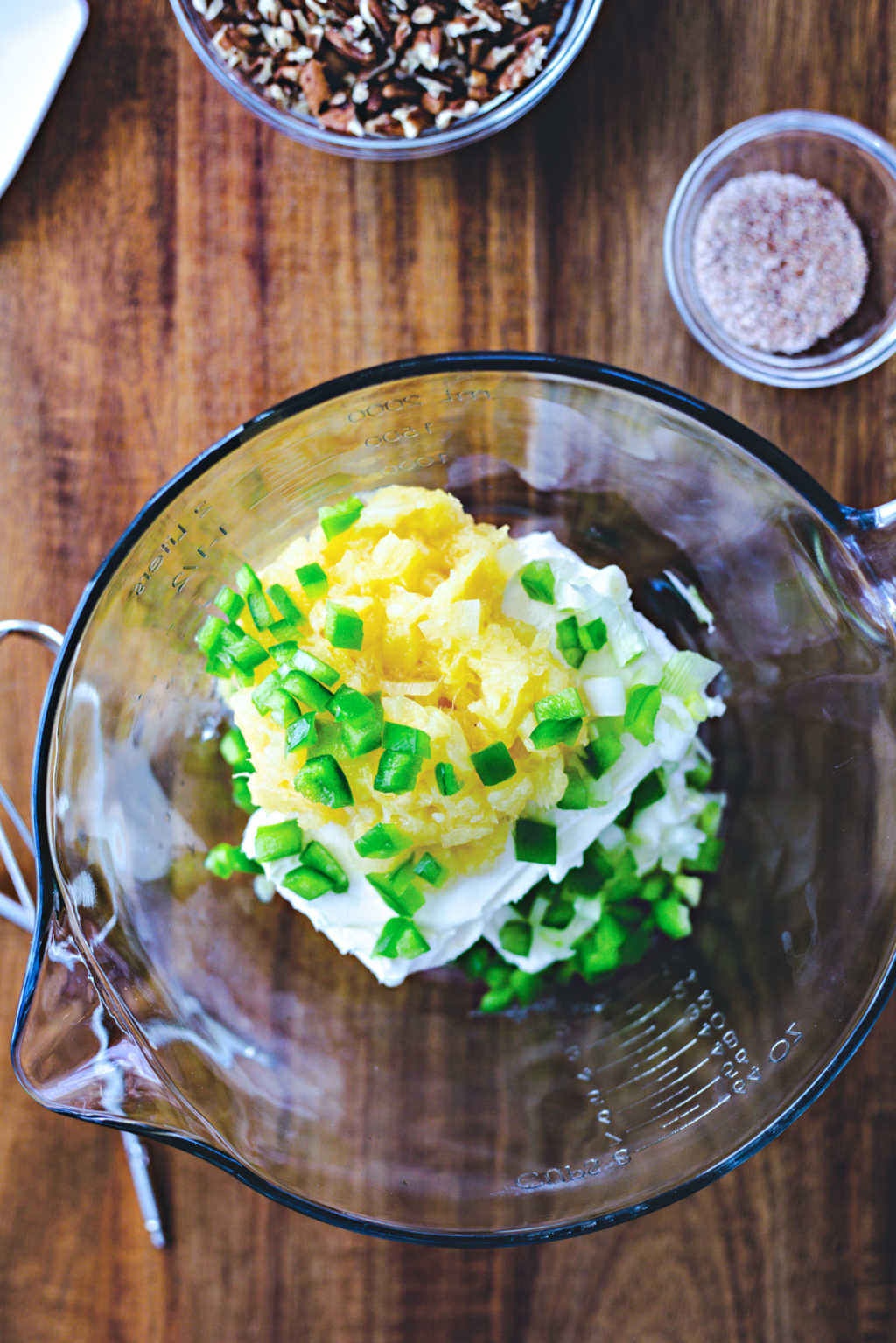 cream cheese with pineapple and green bell pepper in a mixing bowl