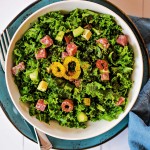 chopped kale salad in a white bowl on a blue plate
