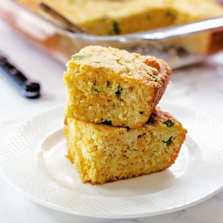 two slices of Mexican cornbread on a white plate on a table