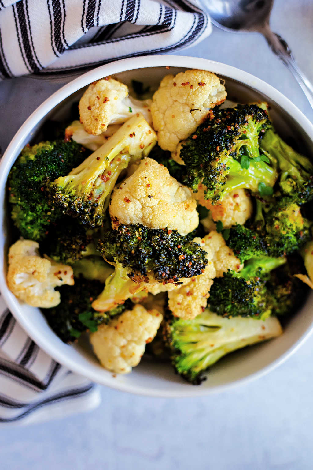Lemon Mustard Roasted Broccoli and Cauliflower in a white bowl on a table