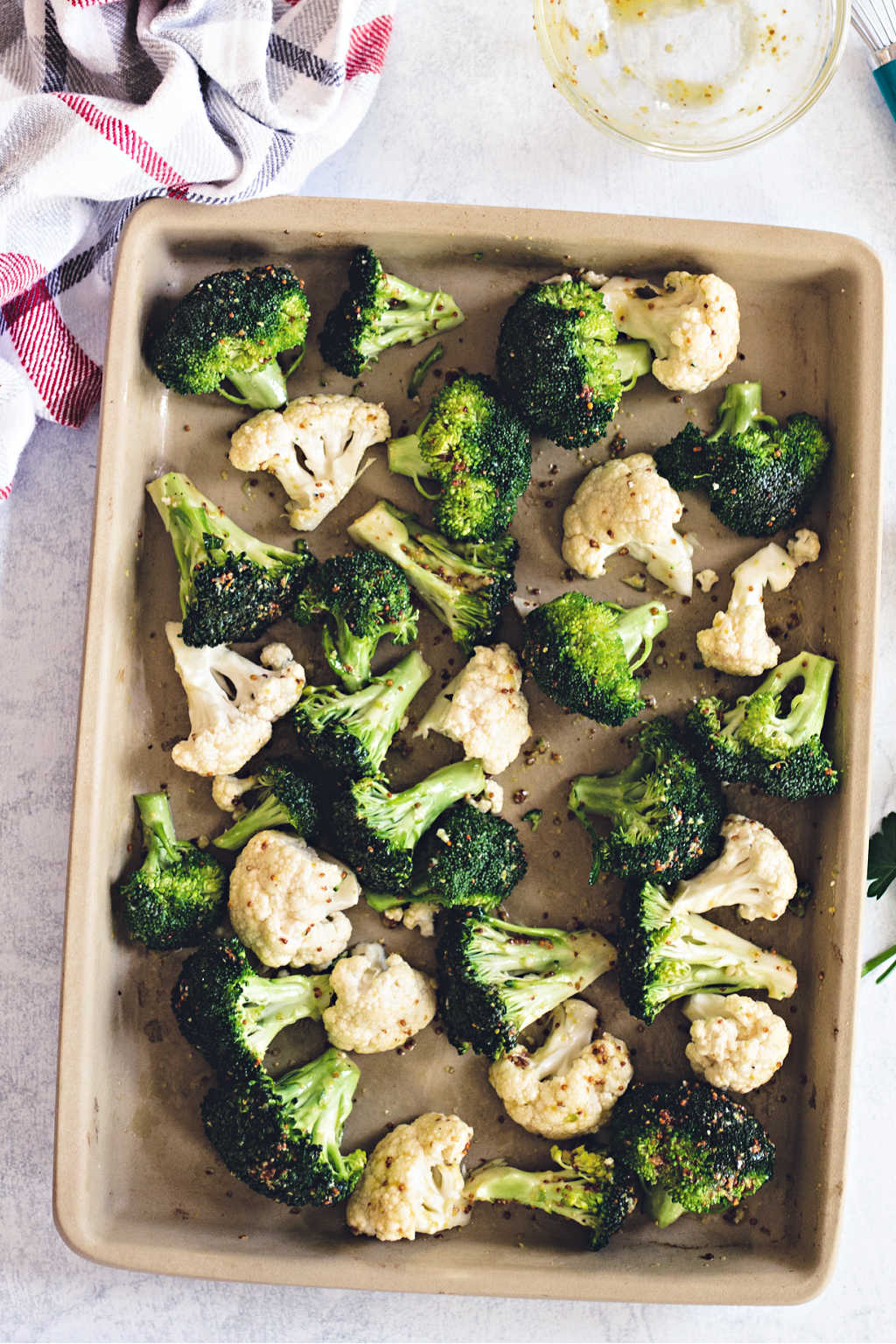 broccoli and cauliflower florets on a baking pan ready for the oven
