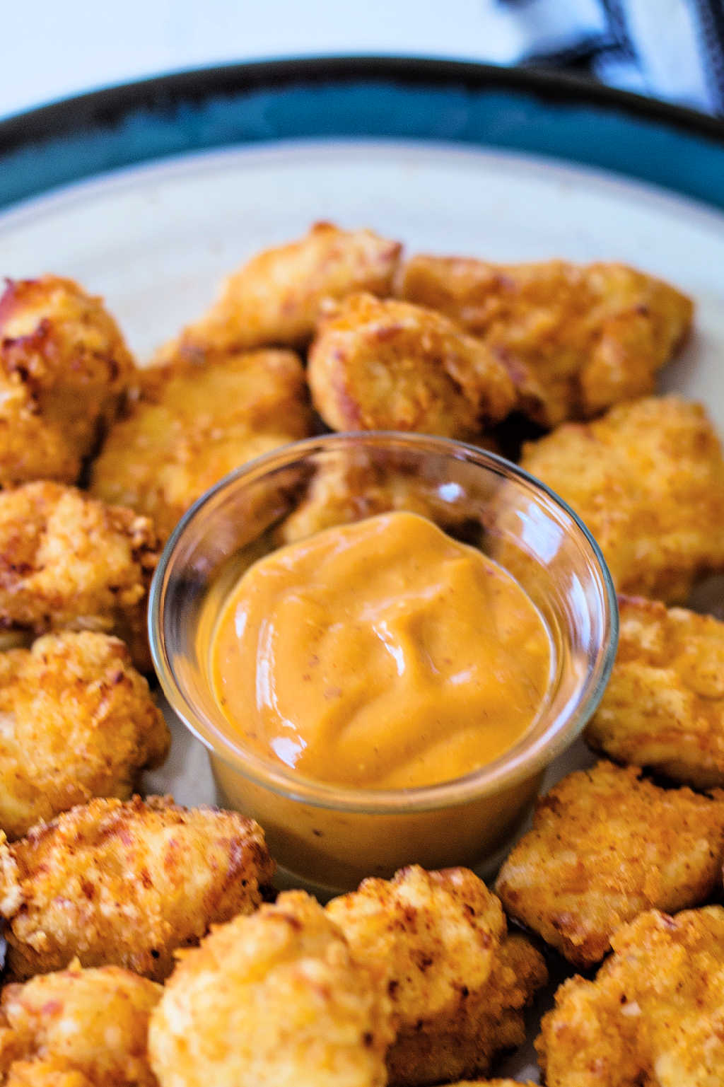 a cup of dipping sauce in the middle of a plate of Chick-fil-A Chicken Nuggets