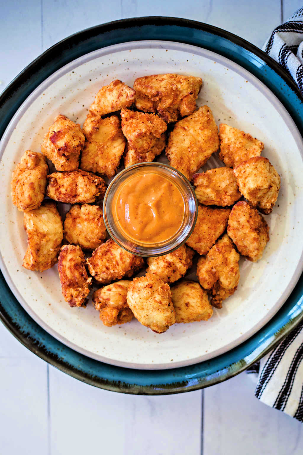 Chick-fil-A Chicken Nuggets on a white plate with a side of dipping sauce.