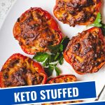 a keto stuffed red bell pepper on a white plate garnished with parsley on a kitchen counter.