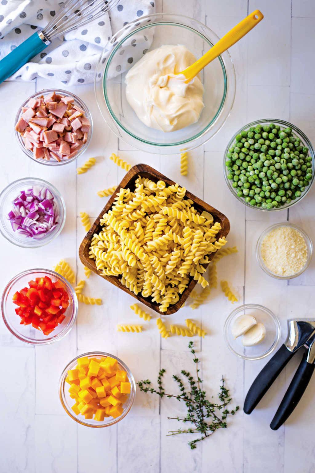 ingredients for macaroni salad with peas on a table.