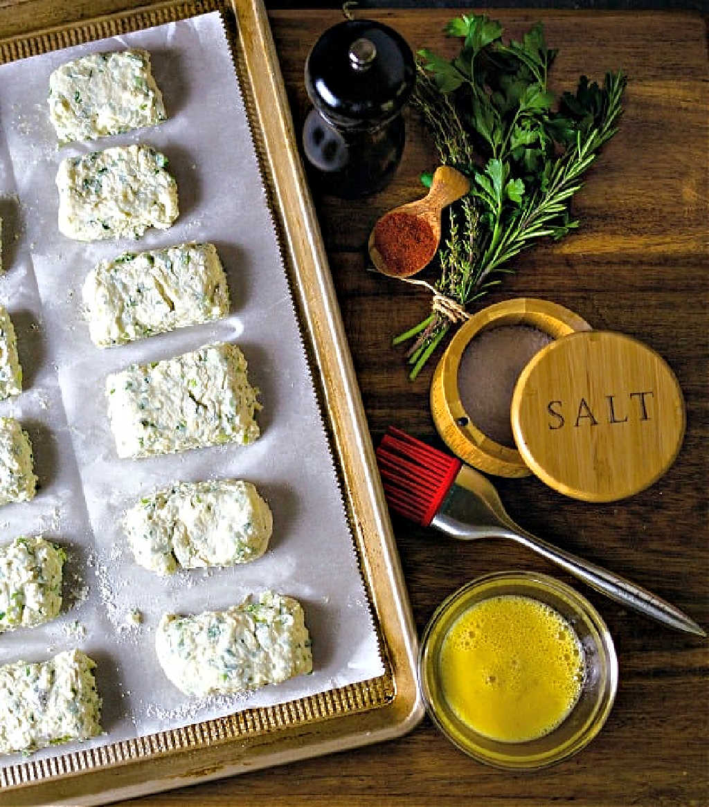 a pan of unbaked savory scones on a wooden table.