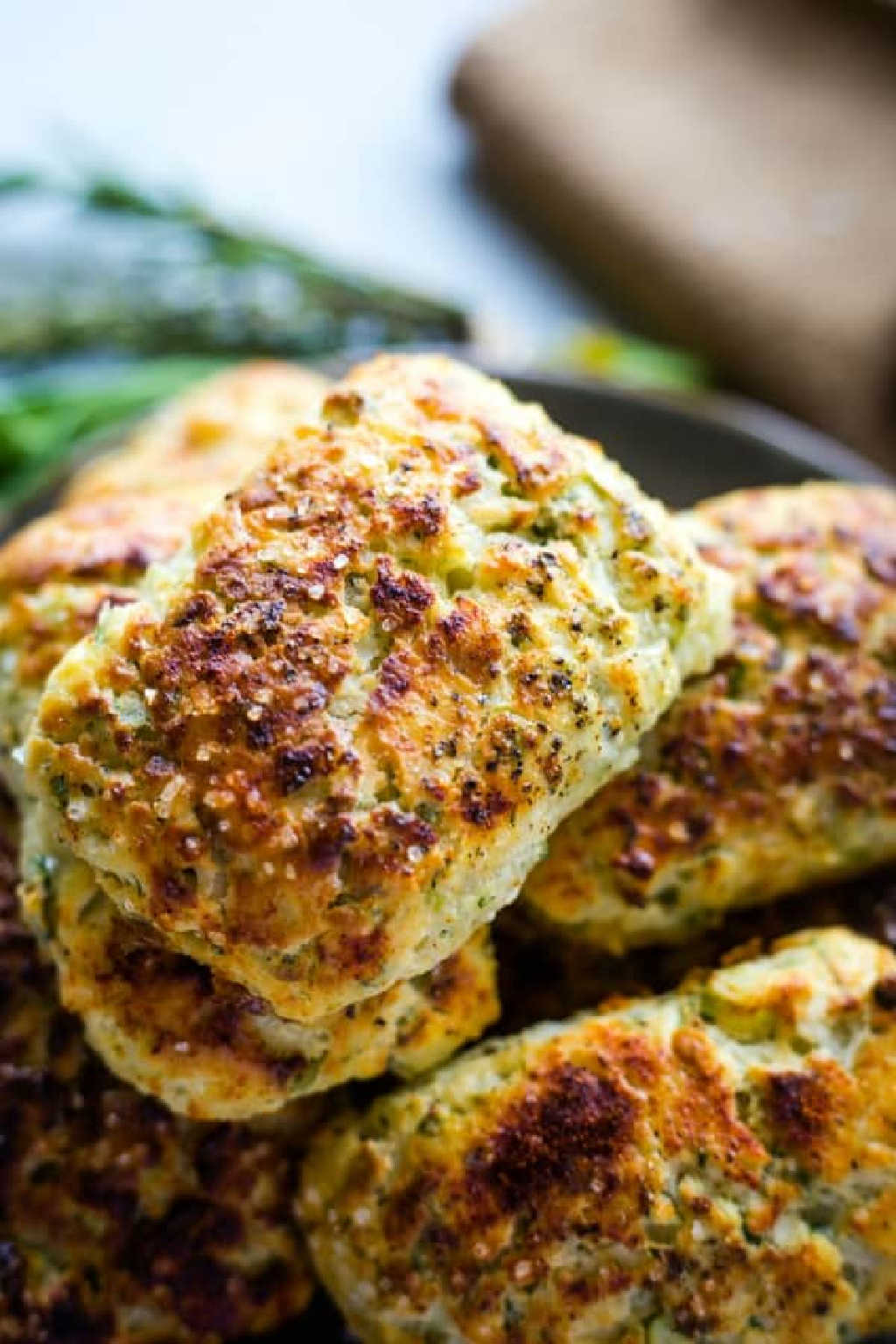 ricotta herb savory scones on a plate on a table with a bundle of fresh herbs.