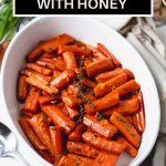 close up photo of Roasted Carrots with Honey in a white dish.
