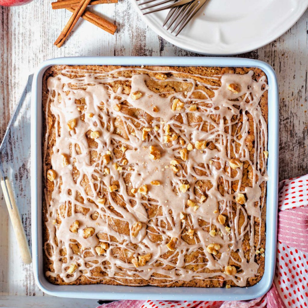 apple walnut cake in a baking pan on a table with a tray.