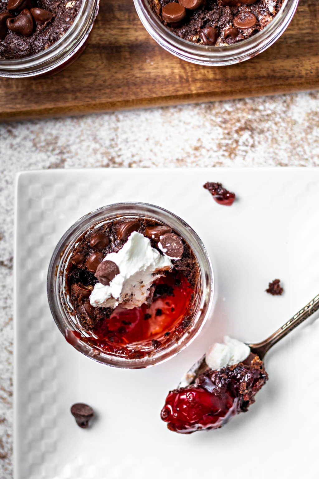 a spoon of chocolate cherry dump cake on a plate on a table.