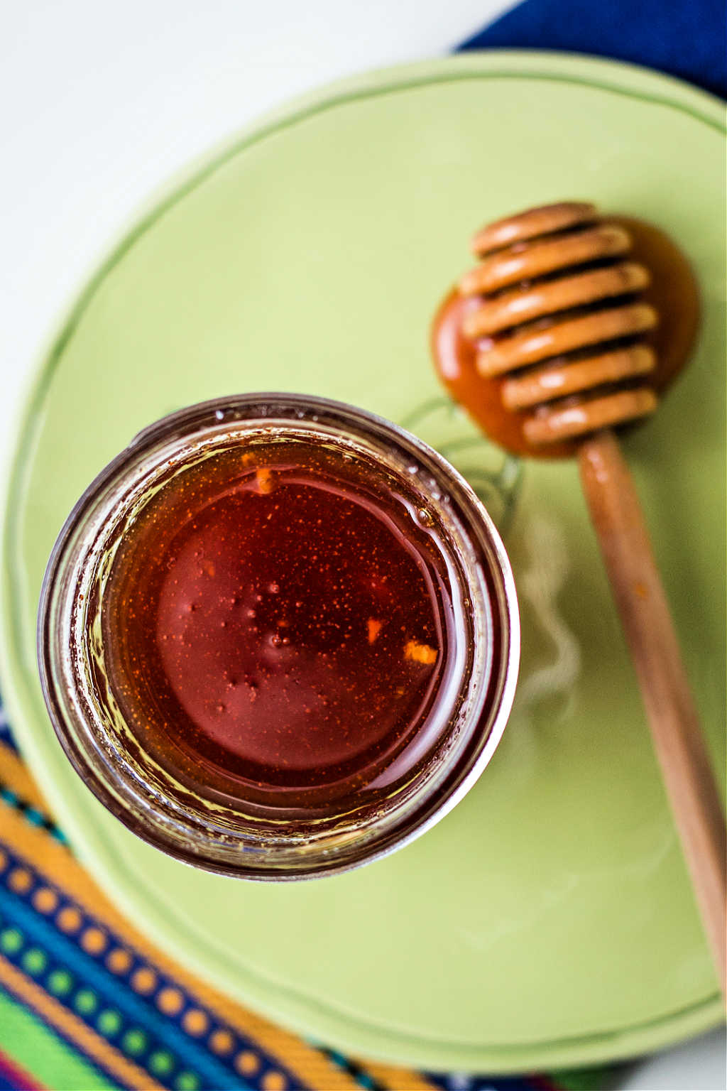 honey sriracha sauce in a jar on a table.