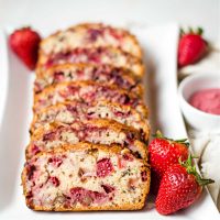 slices of strawberry bread on a white plate on a table.