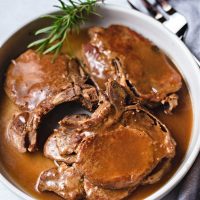 instant pot pork chops with gravy in a white serving dish.