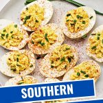 deviled eggs on a white plate garnished with paprika and freshly snipped chives.