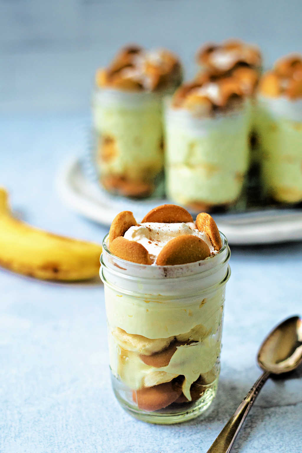no bake banana pudding in small mason jars on a table.