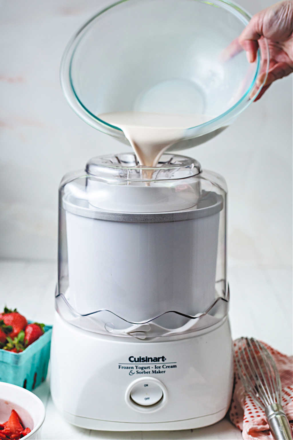 pouring ice cream mixture into a table top ice cream maker.