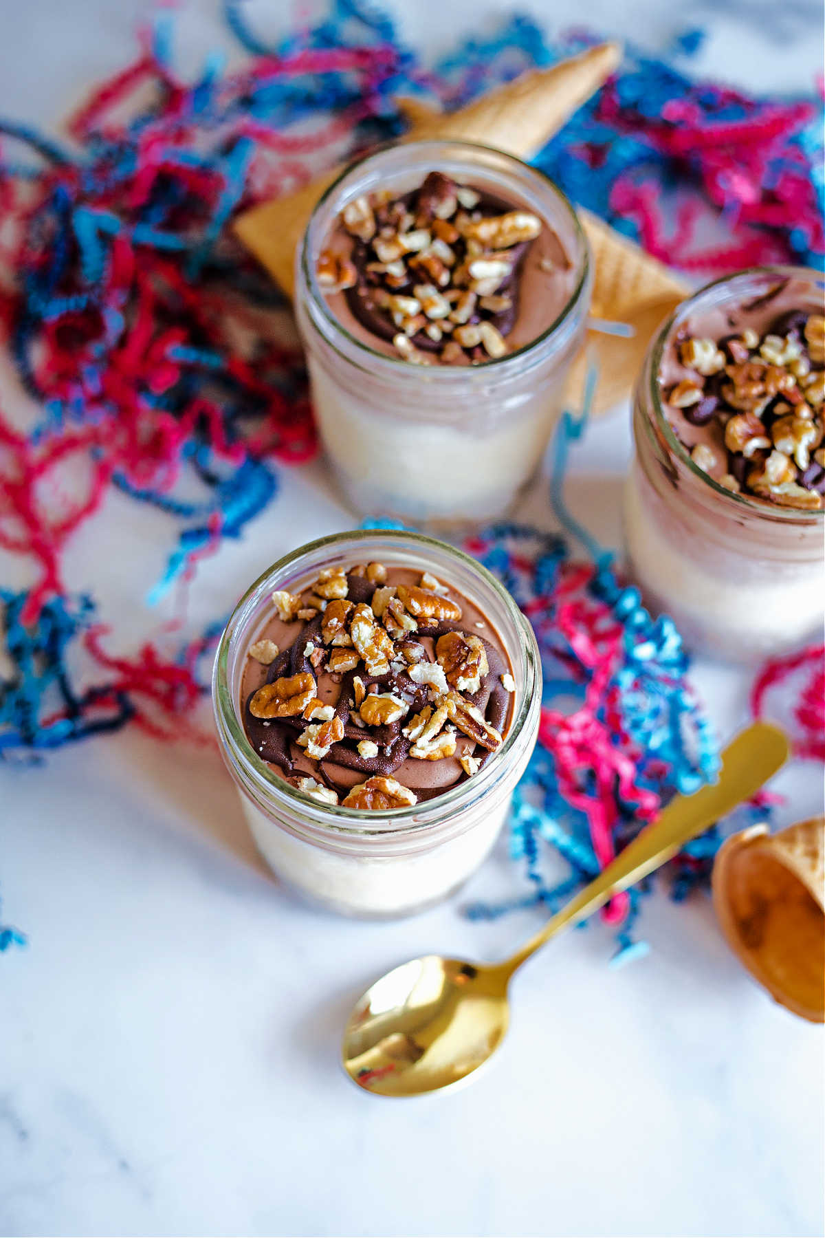 ice cream pie in a jar with chocolate whipped cream, nutella, and nuts.