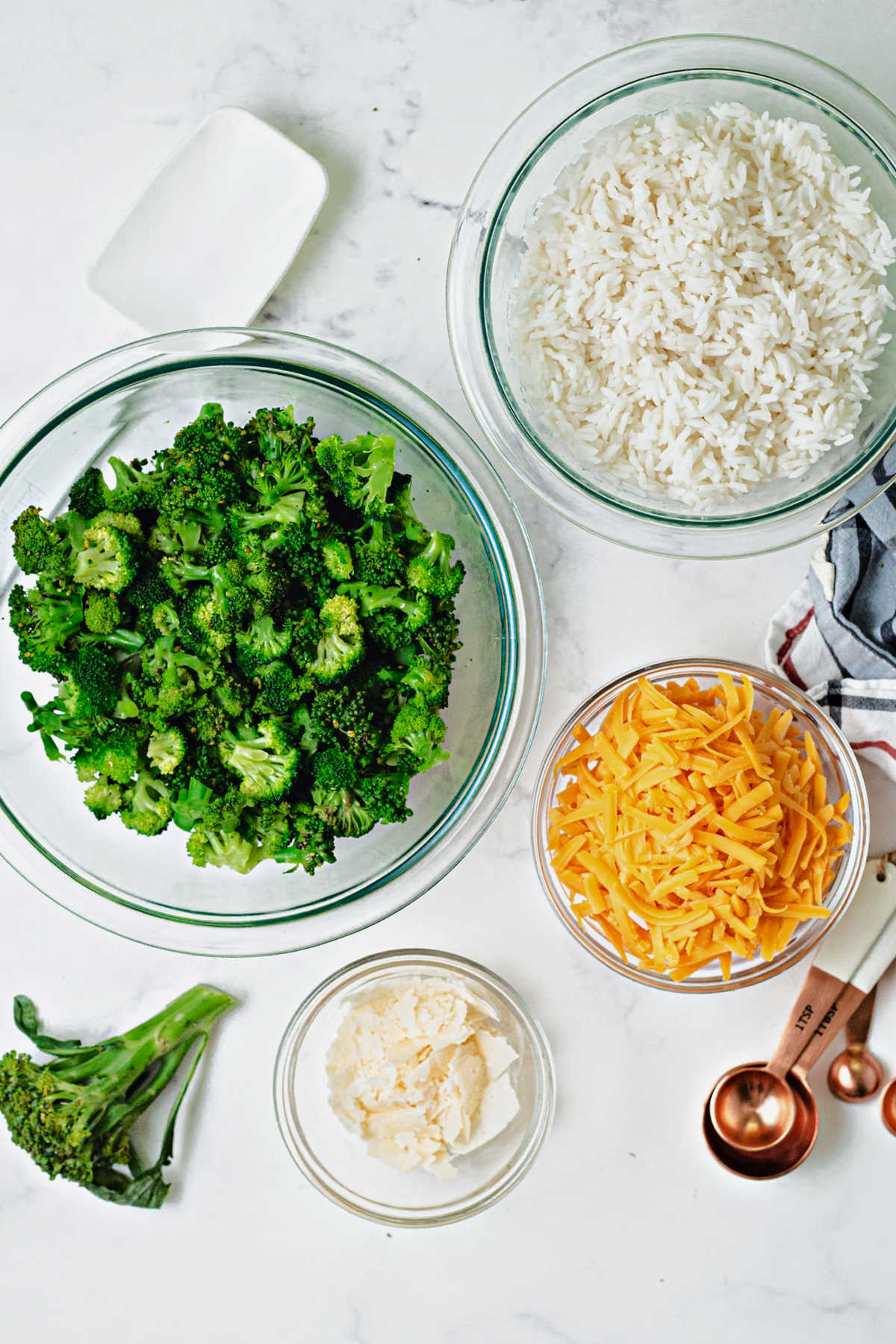 ingredients for a casserole: broccoli, rice, cheddar cheese, parmesan cheese.