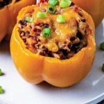 air fryer stuffed pepper with melted cheese on a plate garnished with chopped green onions.