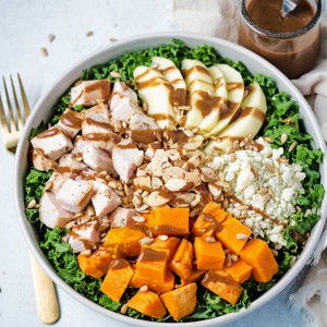 harvest chicken salad in a bowl drizzled with balsamic vinaigrette.