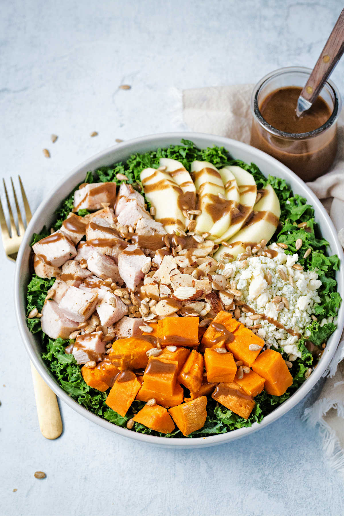 harvest chicken salad in a bowl drizzled with balsamic vinaigrette.