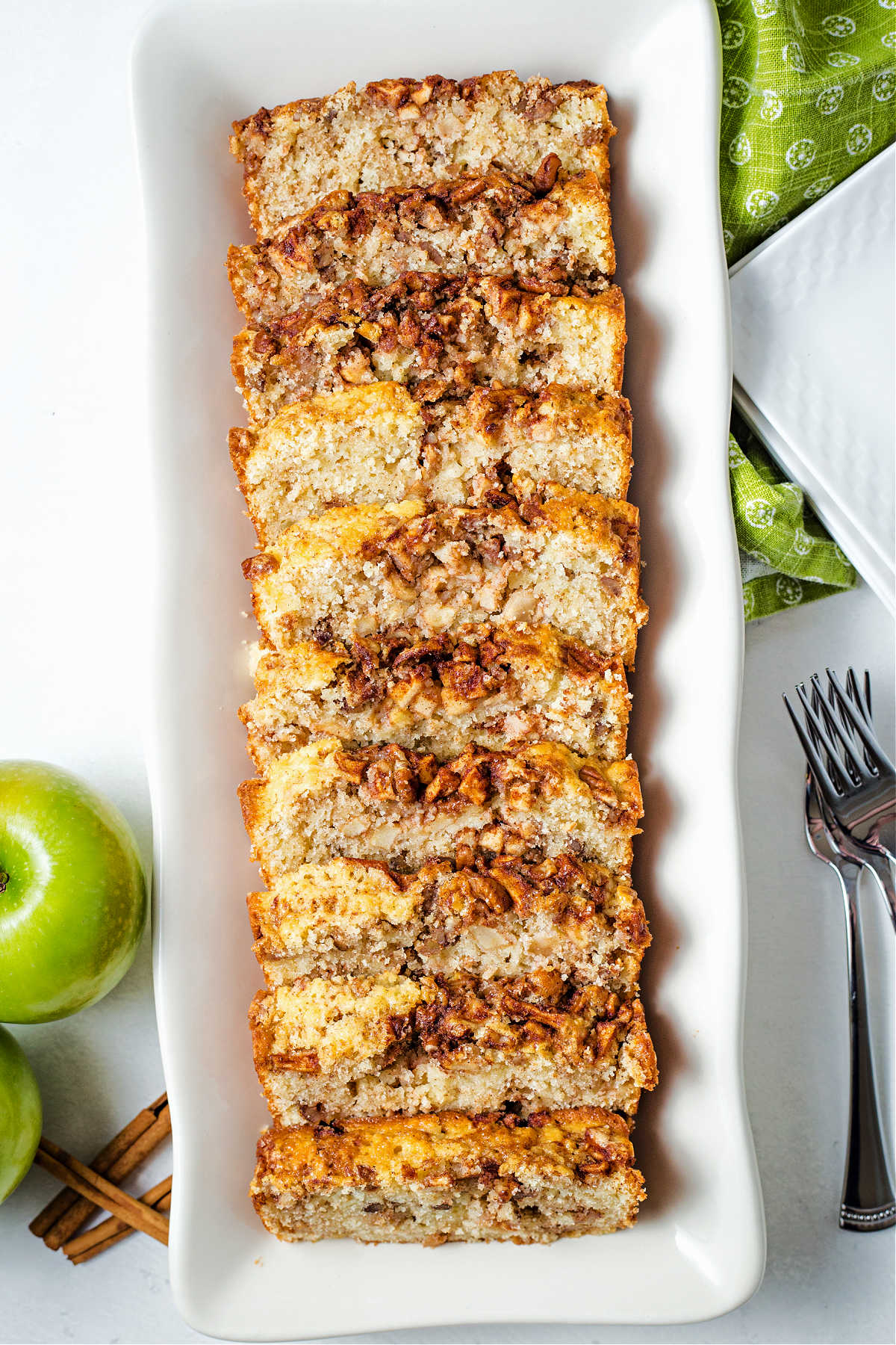 slices of apple cinnamon bread on a white platter on a table.