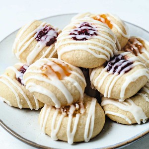 a plate of jam thumbprint lemon short bread cookies with raspberry and orange marmalade filling..