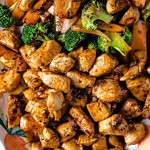 close up shot of hibachi chicken and vegetables on a platter with a serving spoon on the side.
