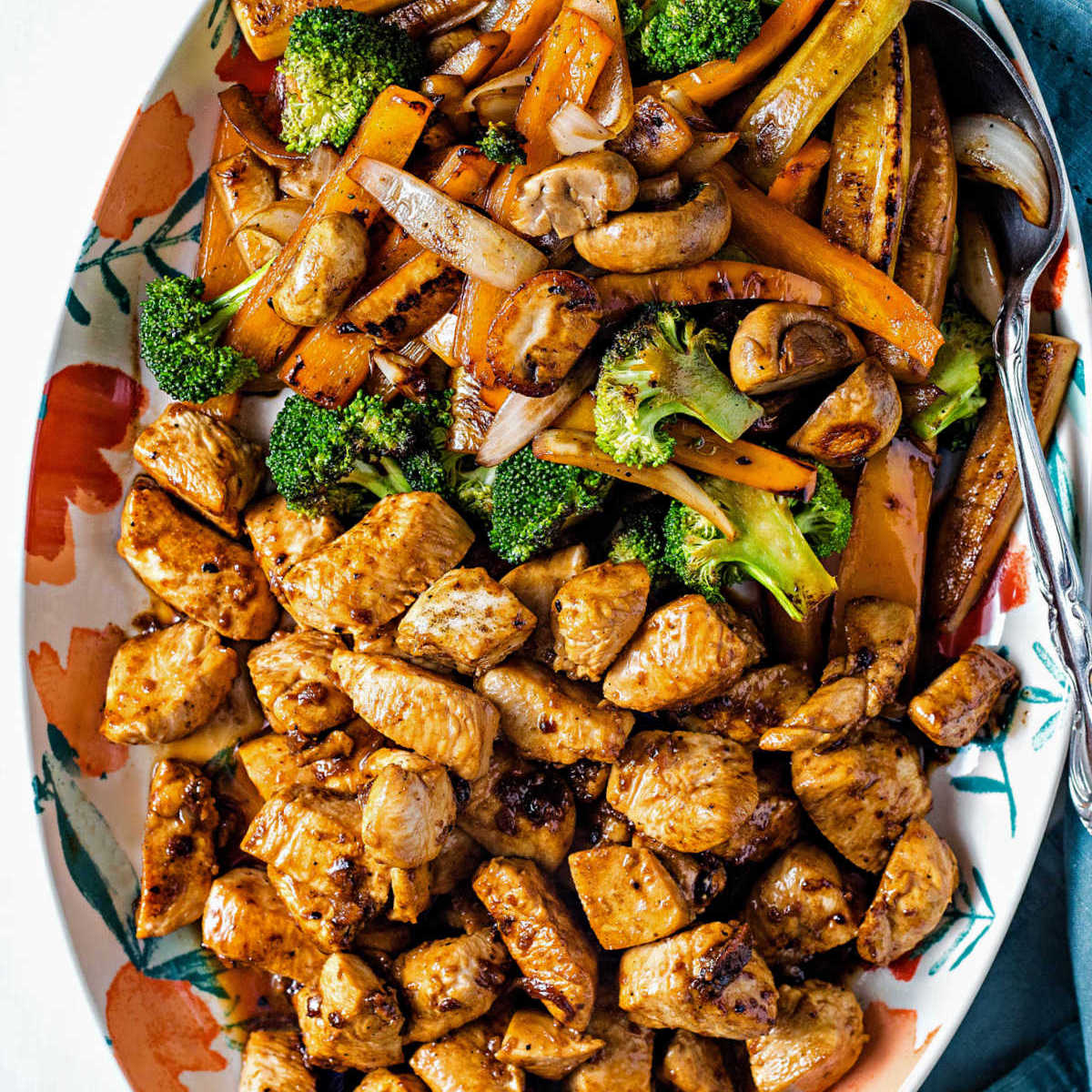 close up shot of hibachi chicken and vegetables on a platter with a serving spoon on the side.