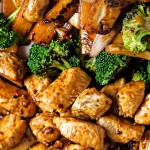 close up shot of hibachi chicken and vegetables on a platter with a serving spoon on the side.