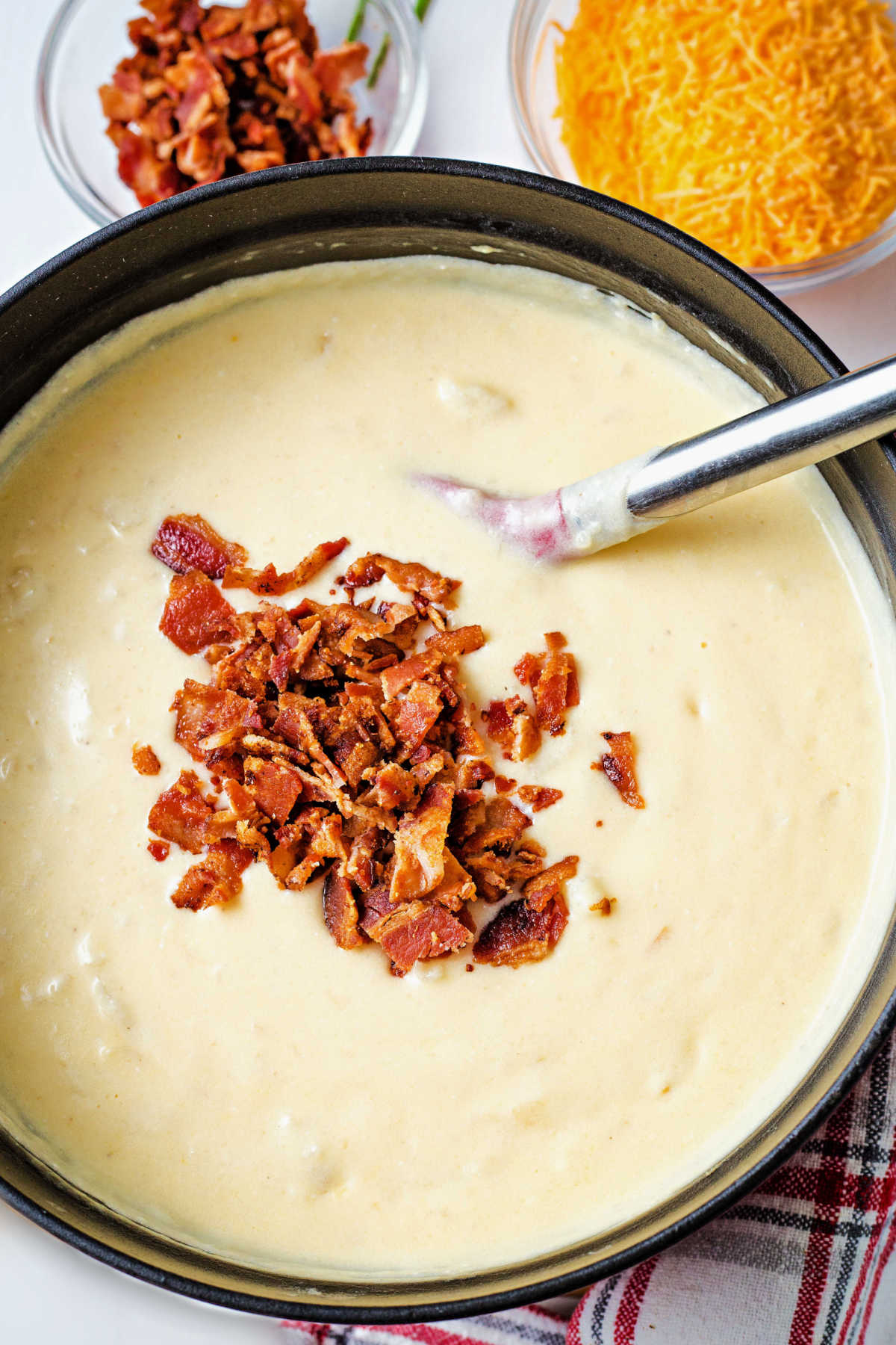 stirring crumbled bacon into a pot of loaded potato soup.