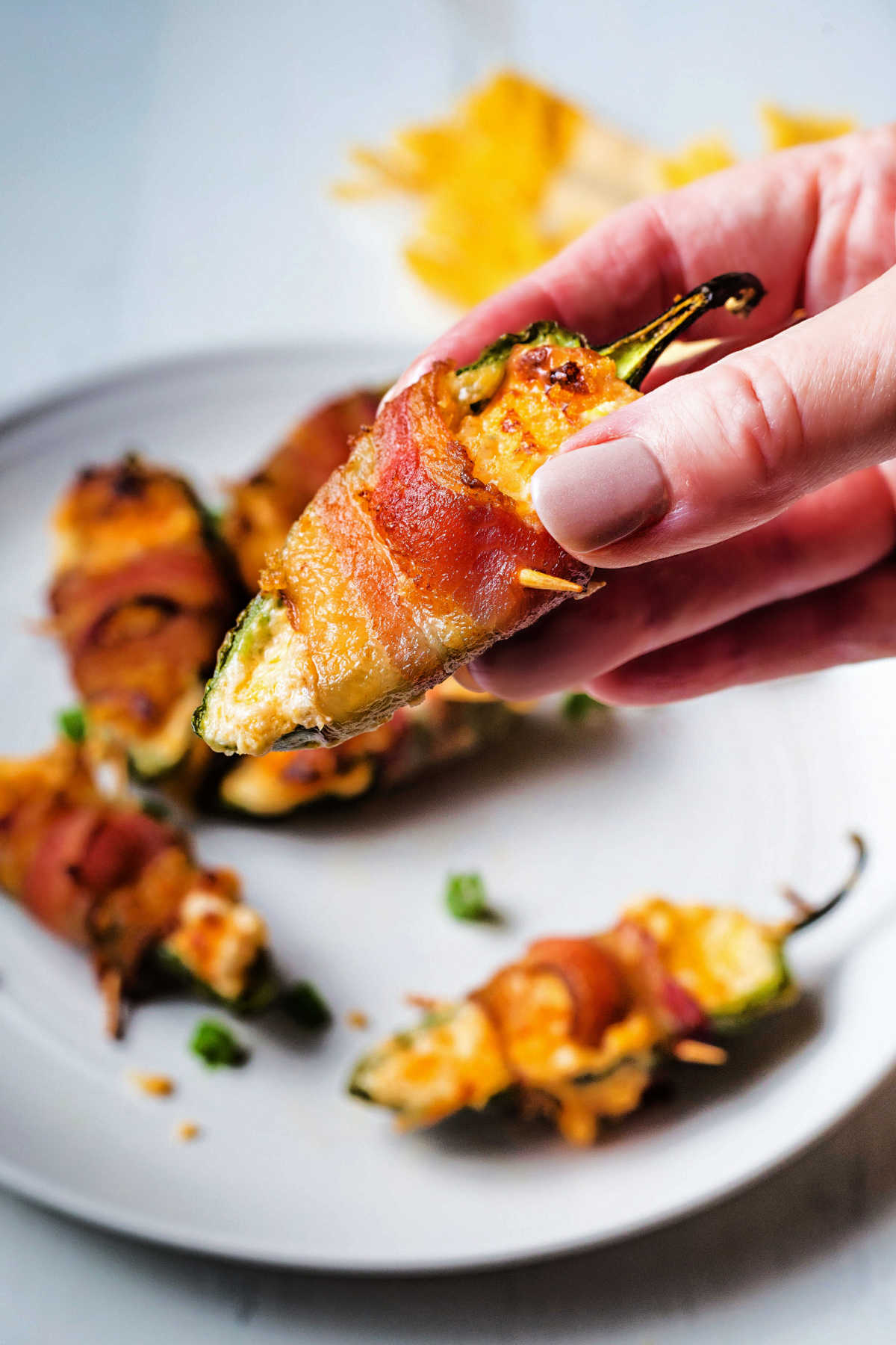 close up shot of a hand holding a jalapeno popper.