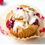 Orange Cranberry Muffin in a paper liner on a table.