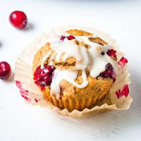 orange cranberry muffin on a parchment paper liner.