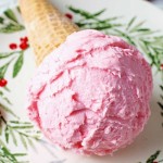 a cone with a scoop of peppermint ice cream laying on a holiday plate.