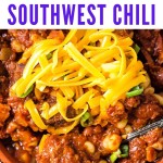 a bowl of slow cooker southwest chili garnished with green onions and cilantro with cheddar cheese.