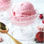 a bowl of peppermint ice cream with a gold spoon sitting on a table.
