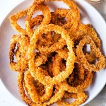 air fried onion rings on a plate on a table.